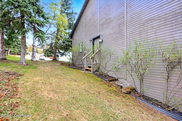 view of side of home with a lawn and entry steps