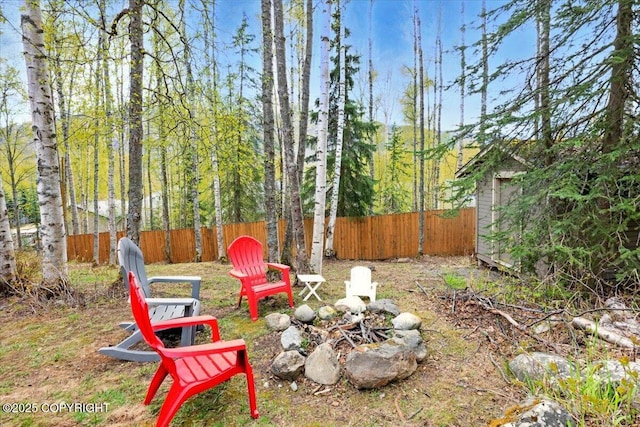 fenced backyard featuring a fire pit