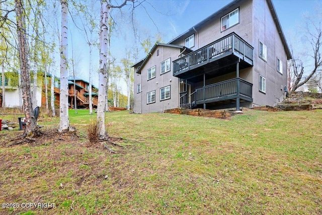 rear view of property featuring a wooden deck and a lawn