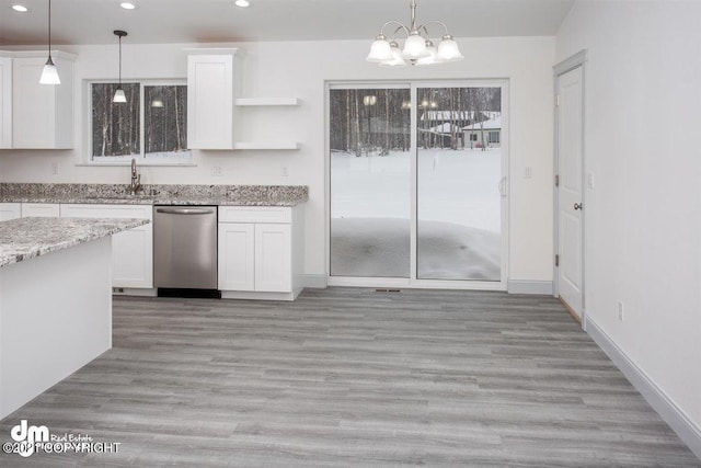 kitchen featuring stainless steel dishwasher, a sink, recessed lighting, a chandelier, and white cabinets