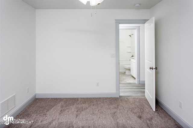 spare room with carpet flooring, baseboards, a ceiling fan, and a smoke detector