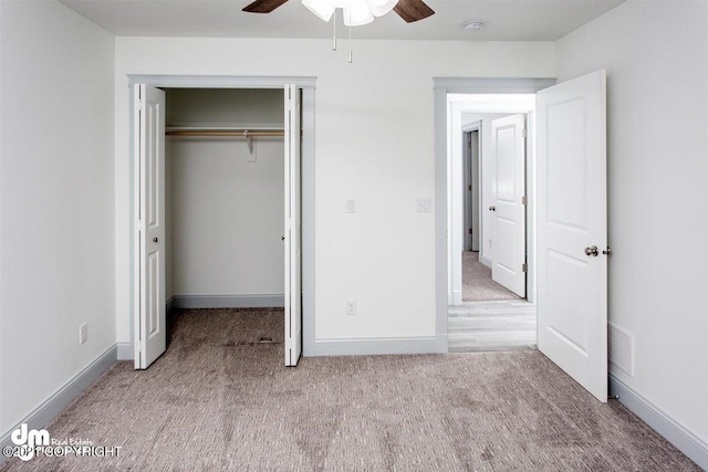unfurnished bedroom featuring carpet flooring, a closet, baseboards, and a ceiling fan