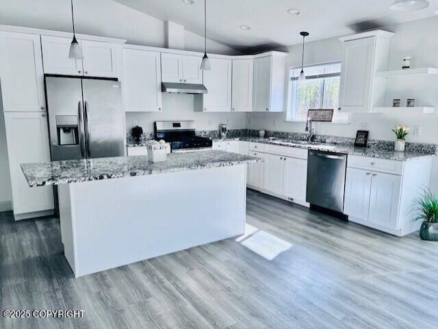 kitchen featuring stainless steel appliances, open shelves, under cabinet range hood, white cabinetry, and vaulted ceiling