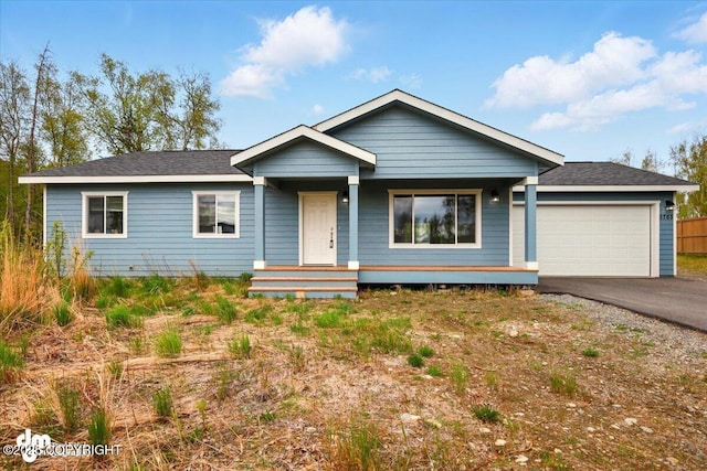 view of front of house featuring a garage, asphalt driveway, and covered porch