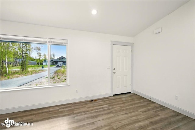 unfurnished room with wood finished floors, baseboards, and recessed lighting