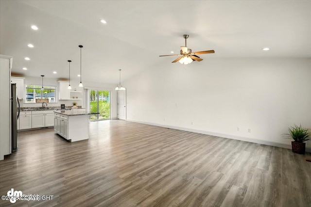 unfurnished living room with a sink, recessed lighting, ceiling fan, dark wood-style flooring, and baseboards