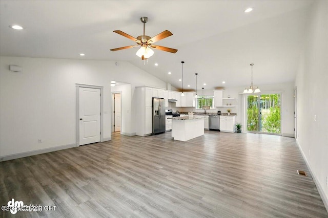 unfurnished living room featuring vaulted ceiling, ceiling fan, light wood-style flooring, baseboards, and a sink