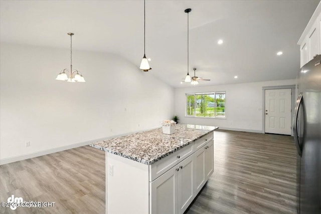 kitchen with freestanding refrigerator, open floor plan, lofted ceiling, a center island, and ceiling fan