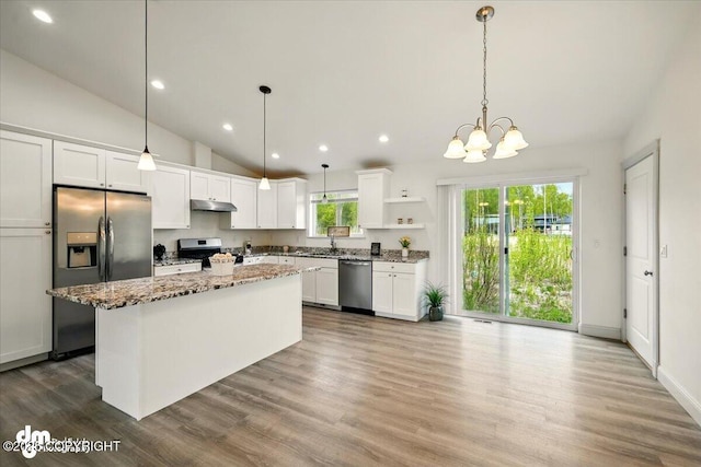 kitchen with appliances with stainless steel finishes, open shelves, under cabinet range hood, a kitchen island, and white cabinets