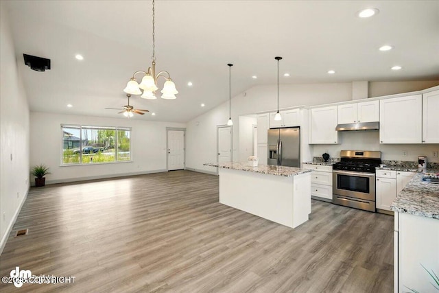 kitchen with stainless steel appliances, under cabinet range hood, lofted ceiling, recessed lighting, and white cabinetry