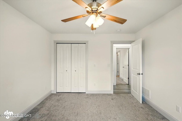unfurnished bedroom with carpet floors, baseboards, a closet, and a ceiling fan