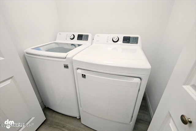 laundry area with washing machine and dryer and wood finished floors