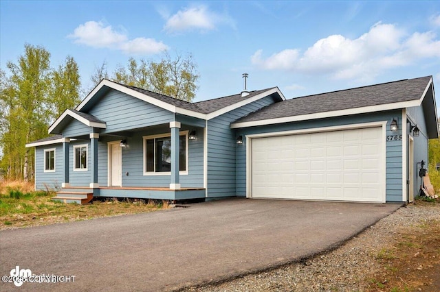 single story home featuring covered porch, asphalt driveway, an attached garage, and a shingled roof