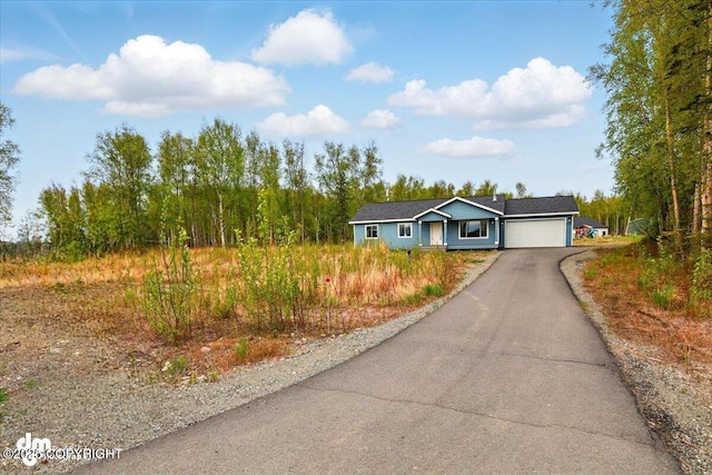 ranch-style home featuring a garage and driveway