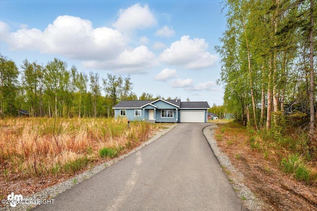 ranch-style house featuring asphalt driveway and a garage