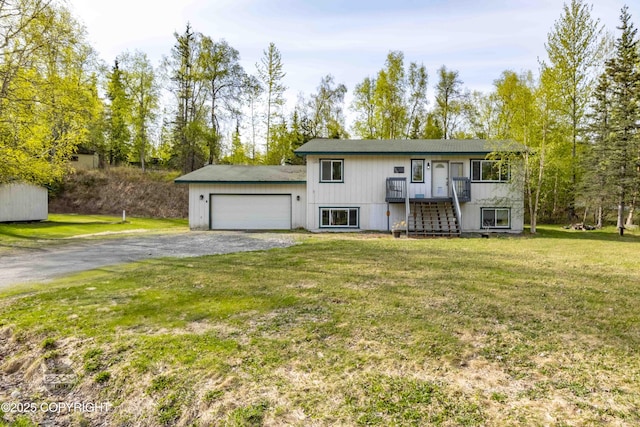 view of front of home featuring an attached garage, dirt driveway, a front lawn, and stairs