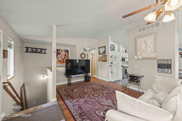 living room with wood finished floors, a ceiling fan, and baseboards