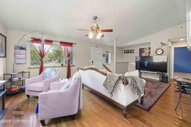 living room featuring a ceiling fan, wood finished floors, and lofted ceiling