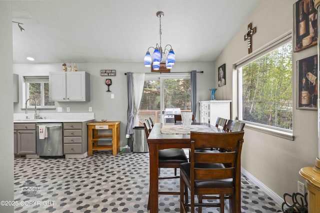 dining area with a chandelier, baseboards, and light floors