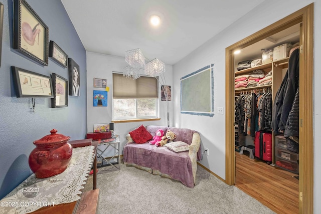 carpeted bedroom featuring a chandelier, a spacious closet, a closet, and baseboards