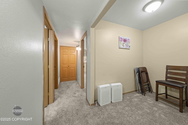 hallway featuring carpet floors and baseboards
