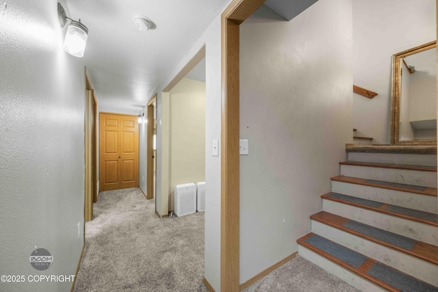 corridor with carpet floors, stairway, and baseboards
