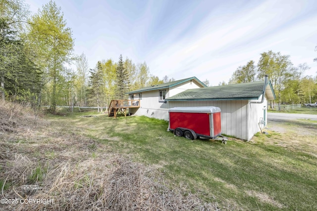 view of side of property with a deck and a yard