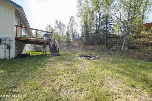 view of grassy yard featuring stairway and a wooden deck