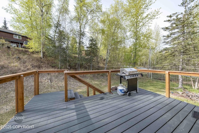 deck with area for grilling and a fenced backyard