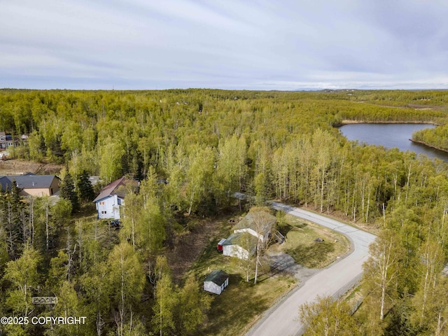 drone / aerial view of a heavily wooded area and a nearby body of water
