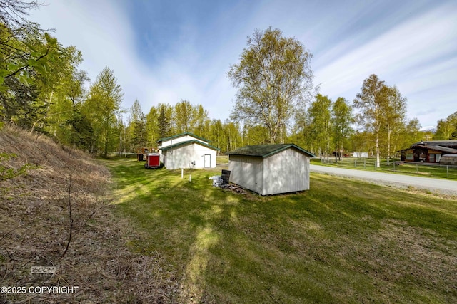 view of green lawn with a shed and an outbuilding