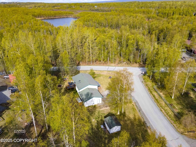 drone / aerial view of a heavily wooded area and a nearby body of water