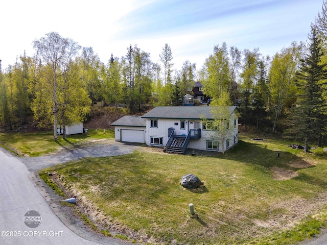 ranch-style home with a front lawn, a detached garage, and an outdoor structure