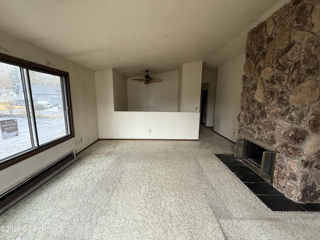 unfurnished living room with ceiling fan, a fireplace, carpet floors, a textured ceiling, and a baseboard radiator