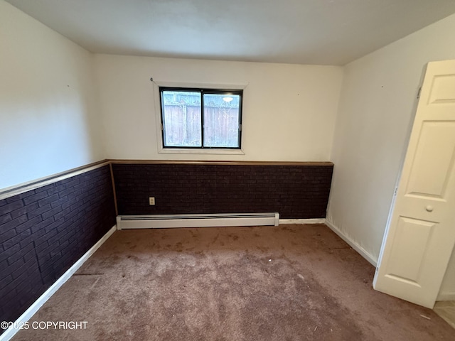 carpeted empty room featuring baseboards, brick wall, and baseboard heating