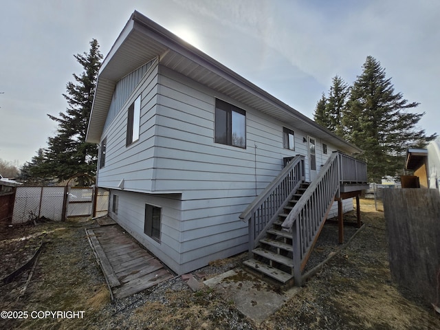 back of property featuring stairway, fence, and a wooden deck