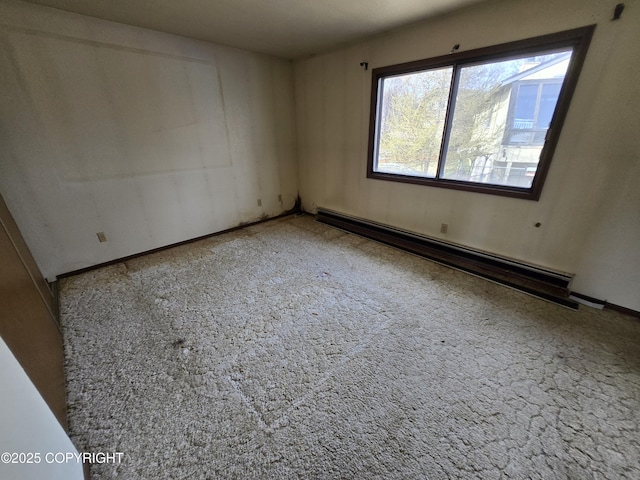 carpeted empty room featuring a baseboard radiator