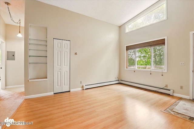 2631 Palmer Ct # C6, Anchorage, AK 99508 - unfurnished room featuring electric panel, light wood-type flooring, baseboards, baseboard heating, and high vaulted ceiling