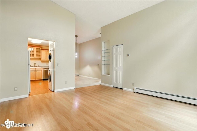 2631 Palmer Ct # C6, Anchorage, AK 99508 - unfurnished room with light wood-type flooring, a sink, baseboard heating, a baseboard radiator, and baseboards