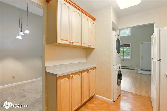 2631 Palmer Ct # C6, Anchorage, AK 99508 - washroom with stacked washer / drying machine, baseboard heating, baseboards, cabinet space, and a textured wall