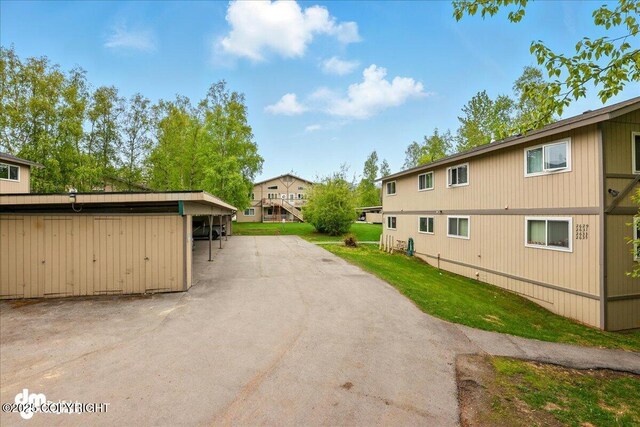 2631 Palmer Ct # C6, Anchorage, AK 99508 - view of side of home with covered parking and a lawn