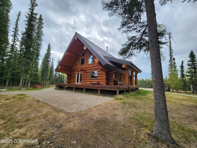 5920 Old Valdez Trl, Salcha, AK 99714 - view of front facade featuring log exterior, a metal roof, a front yard, and a wooden deck