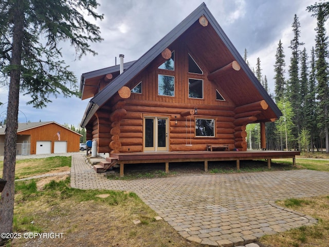 5920 Old Valdez Trl, Salcha, AK 99714 - rear view of house featuring log siding, a detached garage, and an outdoor structure
