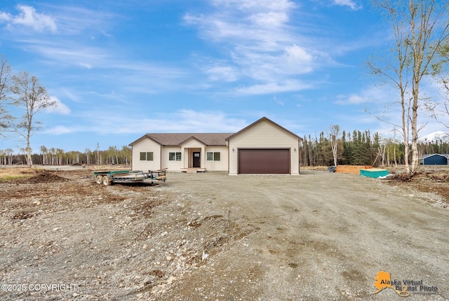 view of front of house with a garage and dirt driveway