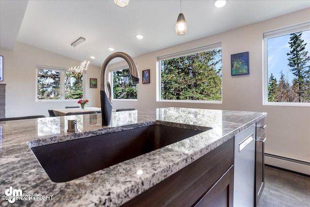 kitchen with light stone countertops, recessed lighting, a sink, and wood finished floors