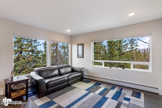 living area featuring a healthy amount of sunlight, wood finished floors, a baseboard heating unit, and recessed lighting