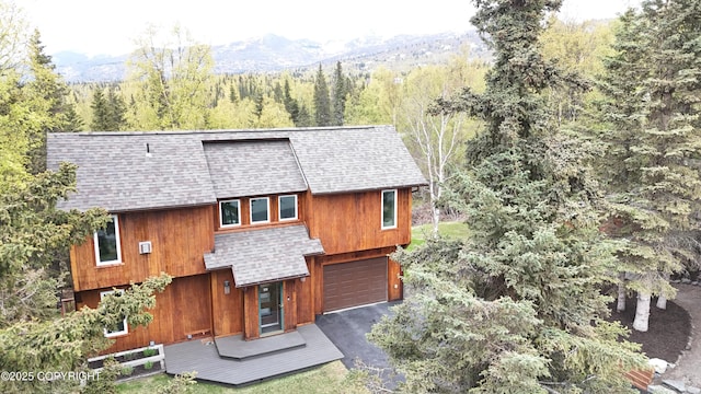 6816 Round Tree Dr, Anchorage, AK 99507 - view of front of home featuring roof with shingles, a forest view, an attached garage, and driveway