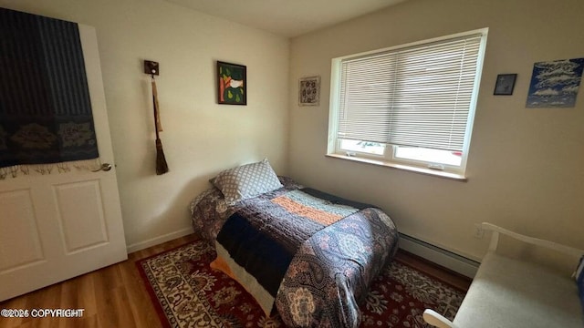 17225 Kimeluk St, Ninilchik, AK 99639 - bedroom with baseboards, a baseboard radiator, and wood finished floors