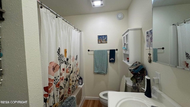 17225 Kimeluk St, Ninilchik, AK 99639 - bathroom with baseboards, toilet, wood finished floors, and shower / tub combo with curtain
