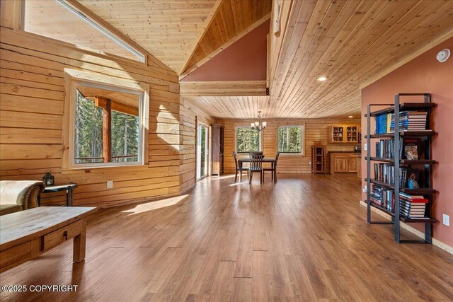 sitting room featuring wooden walls, an inviting chandelier, wood finished floors, vaulted ceiling, and wood ceiling